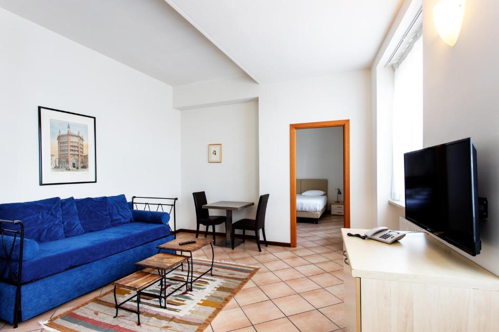 sala de estar con sofá azul y mesa en Residenza Cavour en Parma