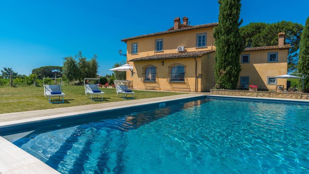a large swimming pool in front of a house at Villa Pucci 12, Emma Villas in Monte San Savino