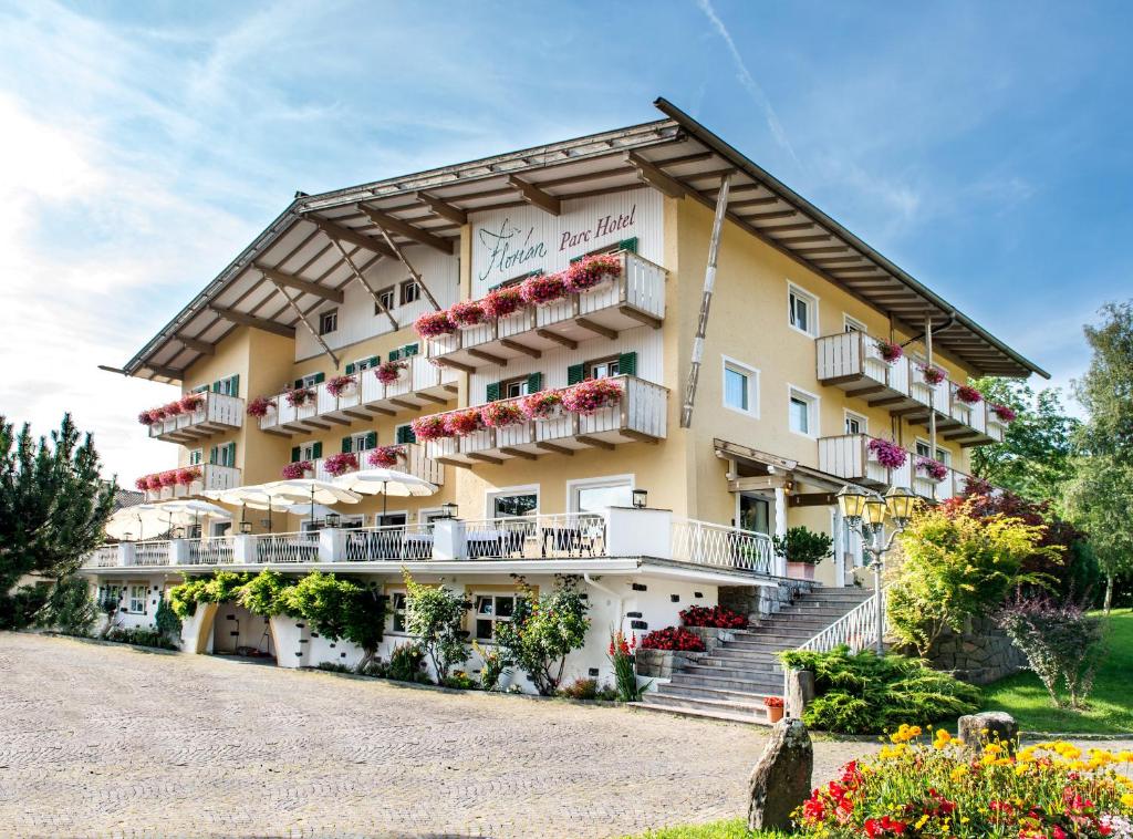 ein großes Gebäude mit Balkonen und Blumen darauf in der Unterkunft Parc Hotel Florian in Seis am Schlern