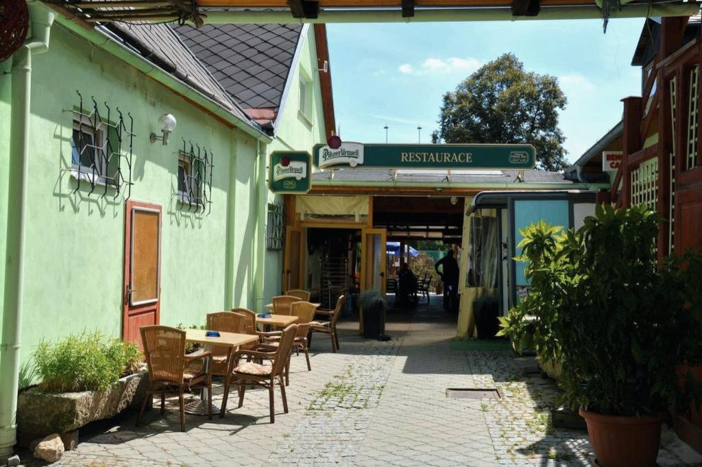 un patio con mesas y sillas fuera de un edificio en Penzion U Šelongů, en Jindřichův Hradec