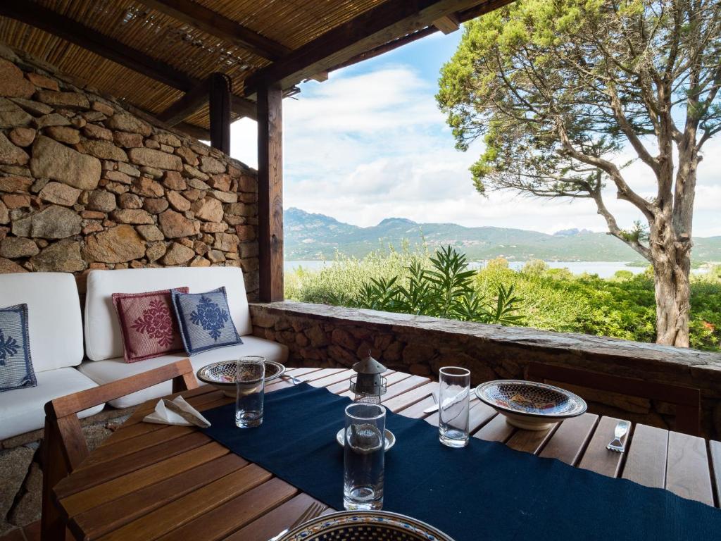 een tafel en stoelen op een veranda met uitzicht op de oceaan bij Casa 93 - Klodge in Porto Rotondo