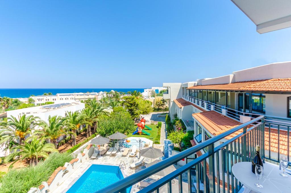 una vista sulla piscina e sull'oceano dal balcone di un resort di Anna Maria Village a Hersonissos