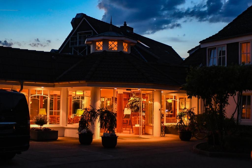 een huis met een gebouw met verlichting in het raam bij Ringhotel Klövensteen in Schenefeld