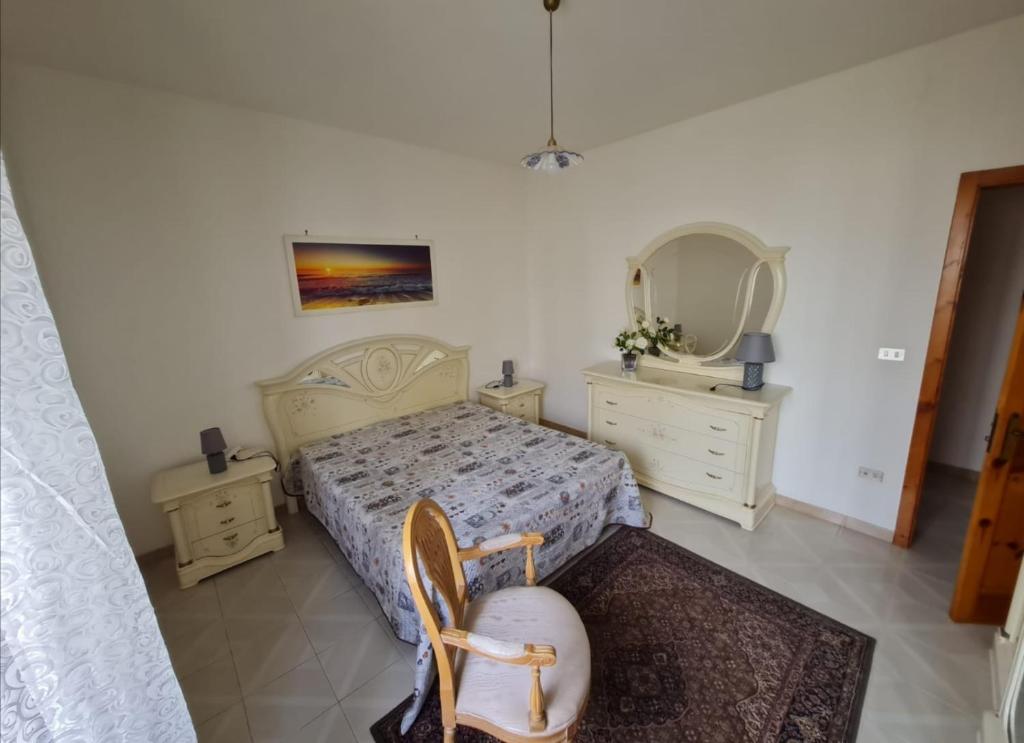 una camera con un letto, due cassettiere e uno specchio di Amata Villa Vacanza a Leuca