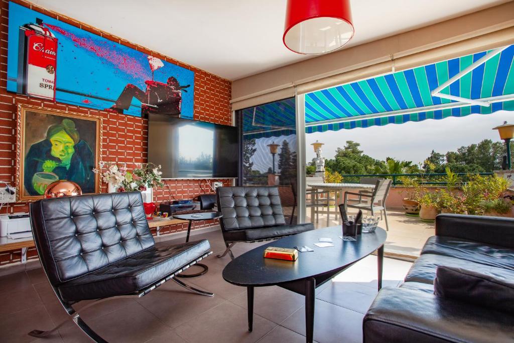 a living room with a couch and chairs and a table at Chrysler Residence in Ganei Tikva