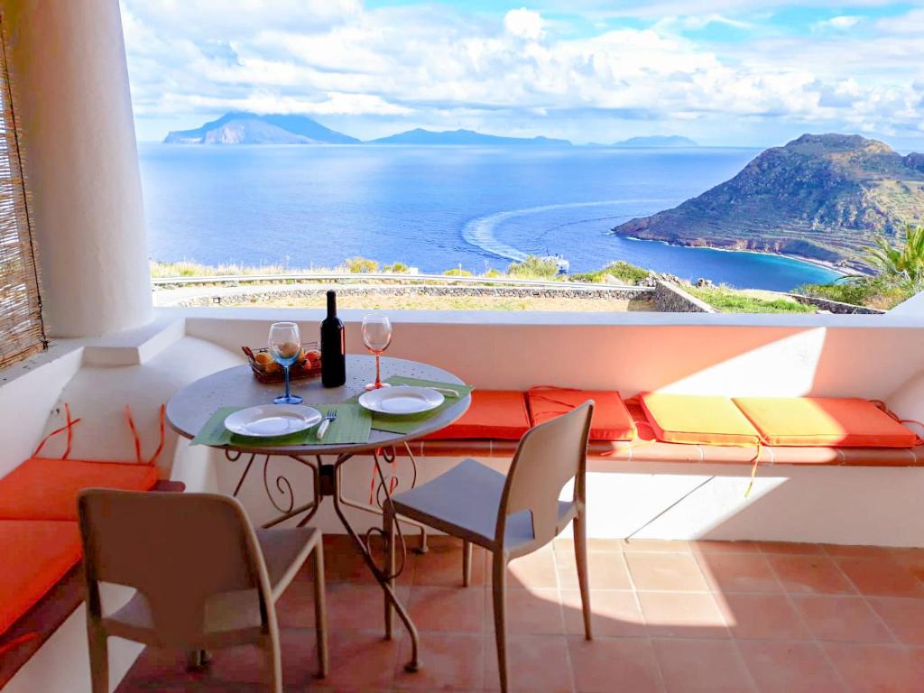 un tavolo e sedie in un balcone con vista sull'oceano di Residence Gregory Filicudi a Filicudi