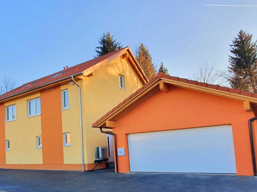 una casa amarilla y naranja con garaje en Gästehaus Traunreut - Monteur und Gästezimmer -, en Traunreut