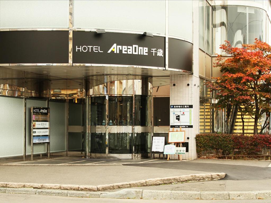 a hotel entrance with a sign in front of it at Hotel AreaOne Chitose in Chitose