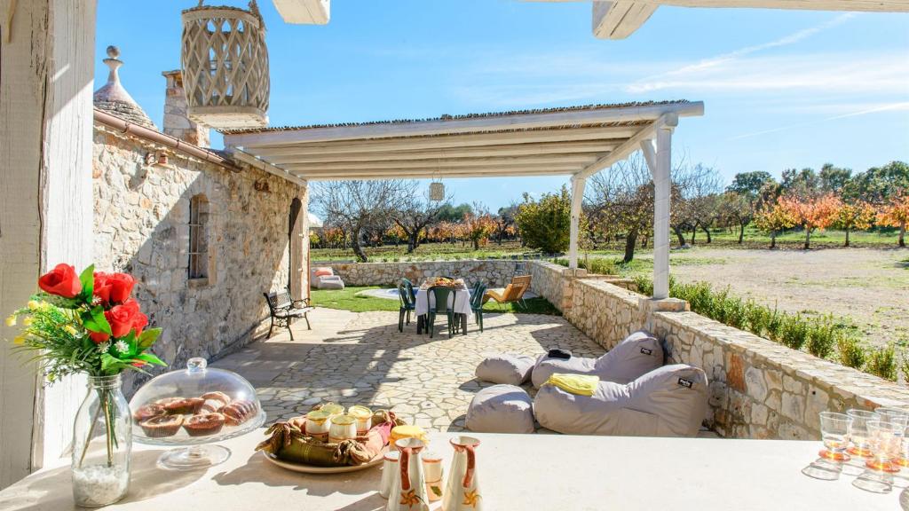 una mesa con platos de comida en el patio en Trulli Littoria 4, Emma Villas en Castellana Grotte