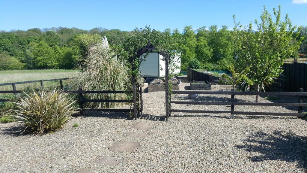 una valla de madera con un arco en un patio en Sheepwash Shepherds Hut, en Bebside