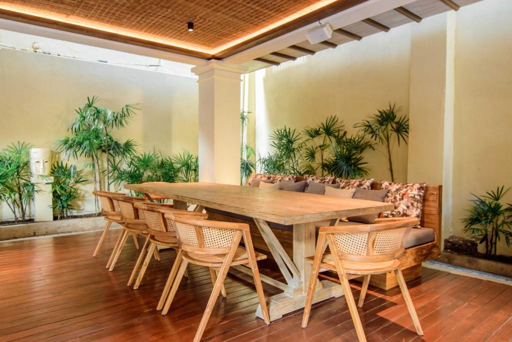 a wooden table and chairs in a room with palm trees at The Merchant in Galle