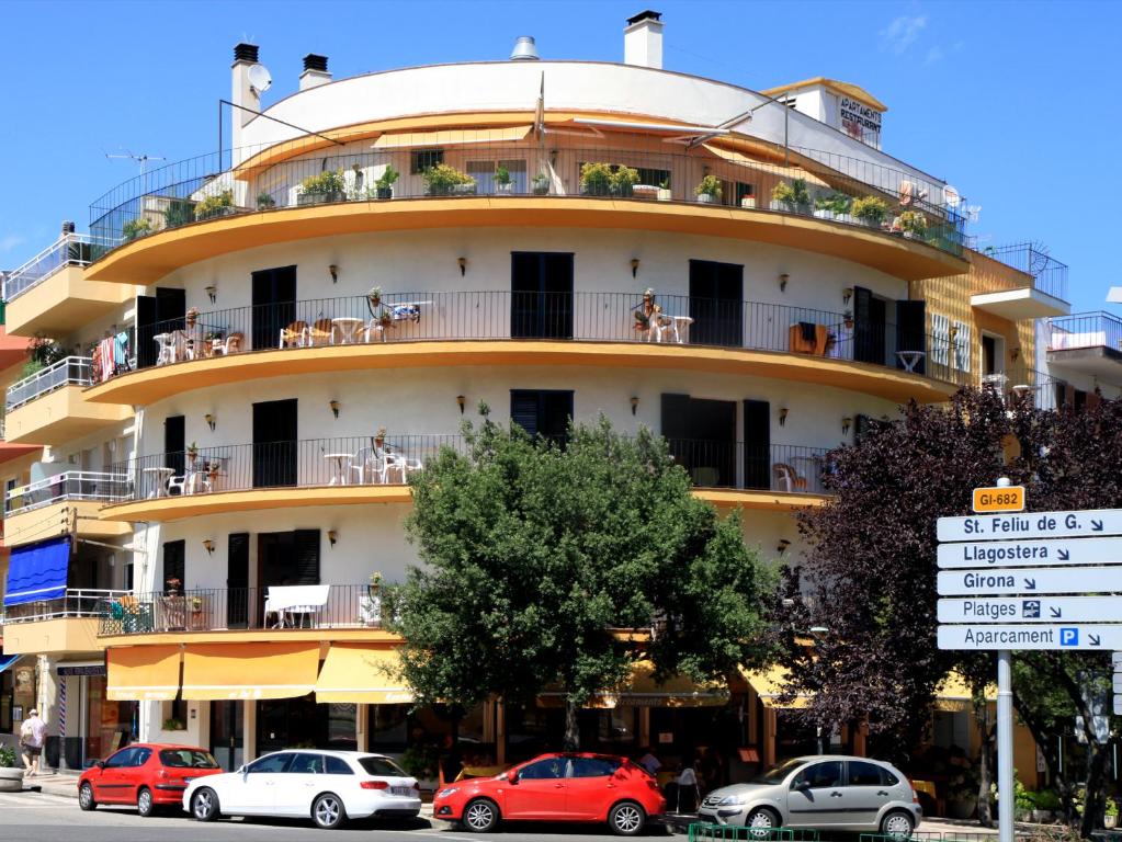 ein großes Gebäude mit davor geparkt in der Unterkunft Apartamentos El Sol in Tossa de Mar