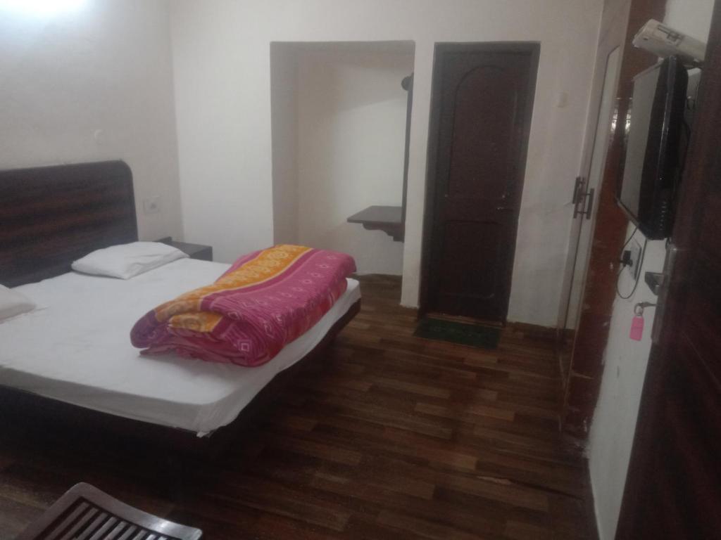 Dormitorio pequeño con cama y TV en HOTEL JOGI GUEST HOUSE, en Amritsar