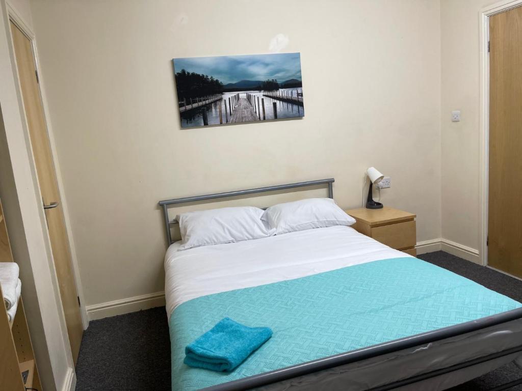 Un dormitorio con una cama con una toalla azul. en Sangha House en Leicester