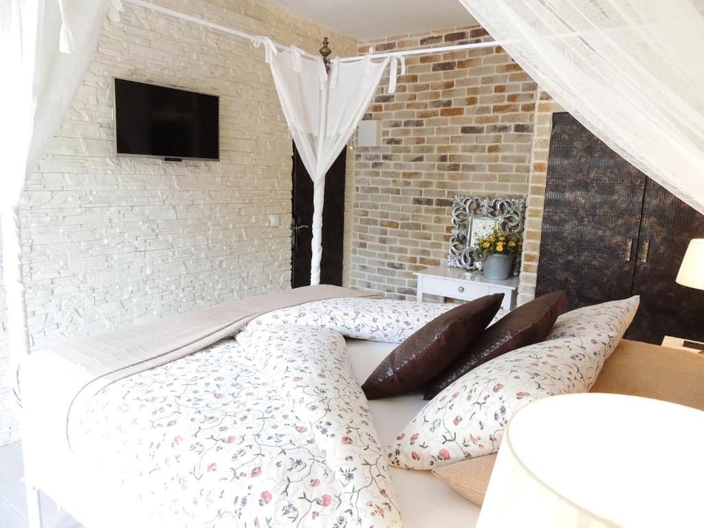 Schlafzimmer mit einem Bett mit Kissen und einem TV in der Unterkunft Villa Palmer I Beachhouse in Paguera