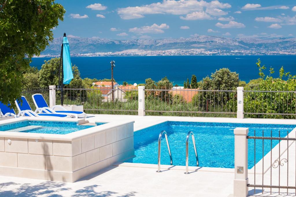 - une piscine avec des chaises et une vue sur l'eau dans l'établissement Villa Agape, à Mirce
