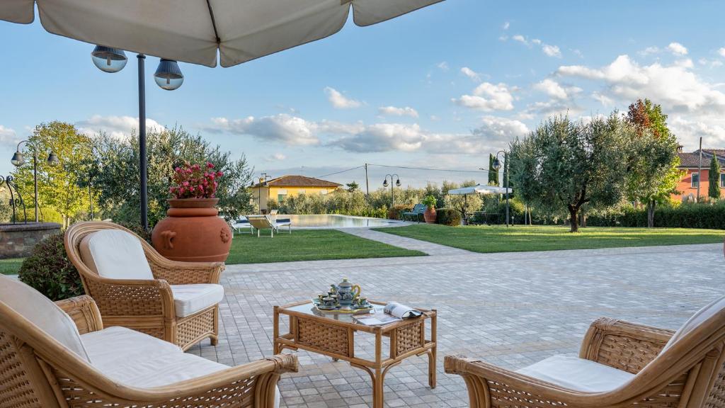 a patio with chairs and an umbrella and a table at VILLA GABRI 8&2, Emma Villas in Montecarlo