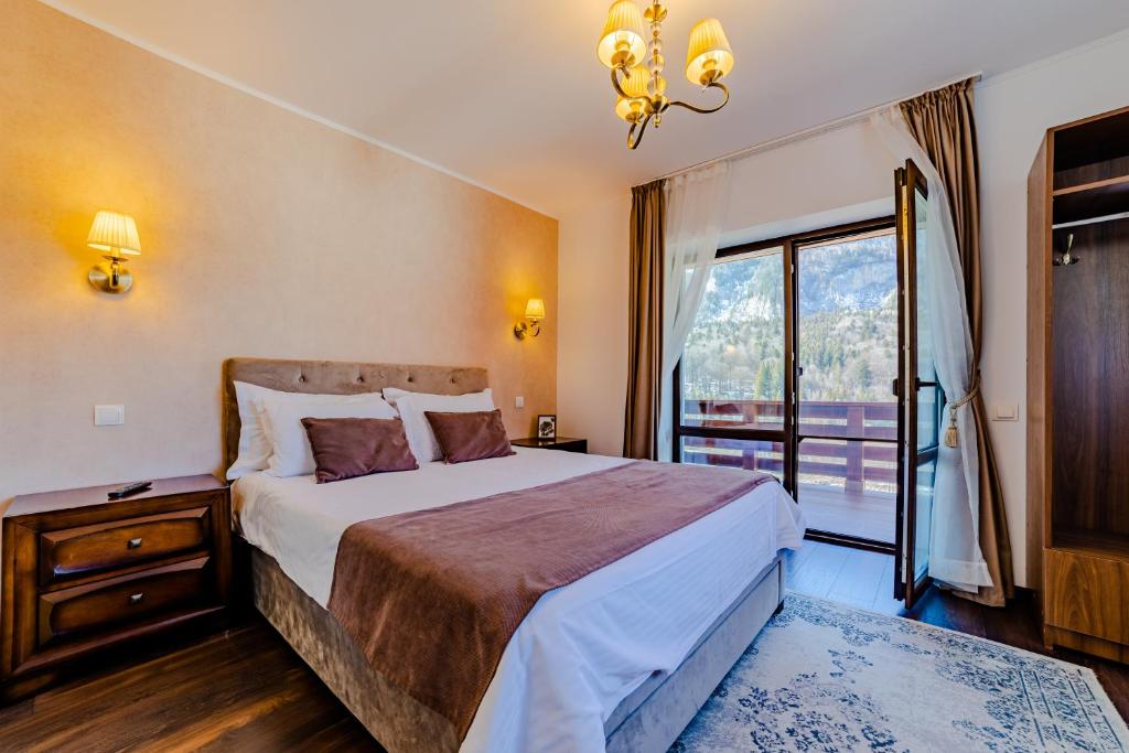 a bedroom with a large bed and a window at Yael Luxury Apartments 3 in Buşteni