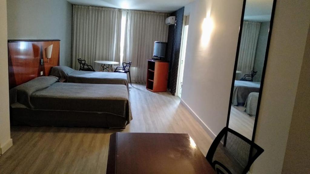 Pokój hotelowy z 2 łóżkami i lustrem w obiekcie Cristal Palace Hotel w BuenosAires
