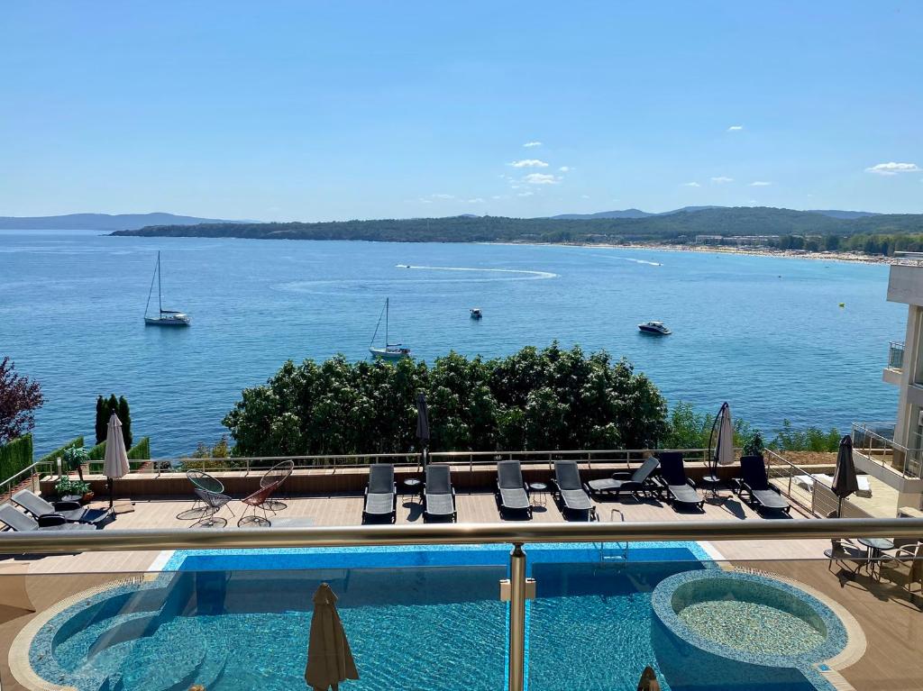 uma piscina com cadeiras e vista para a água em Solinaria Boutique Hotel em Sozopol