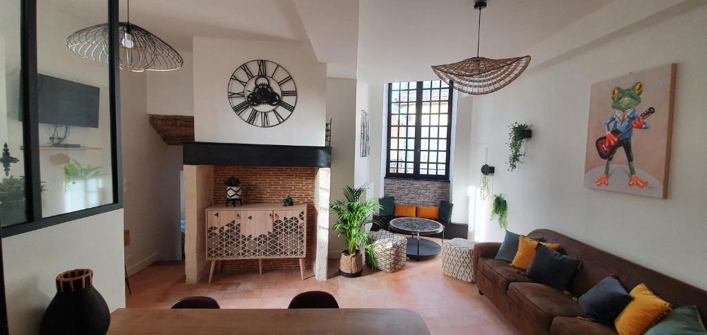 uma sala de estar com um sofá e uma lareira em Appartement Duplex au Coeur du Centre Historique em Bergerac