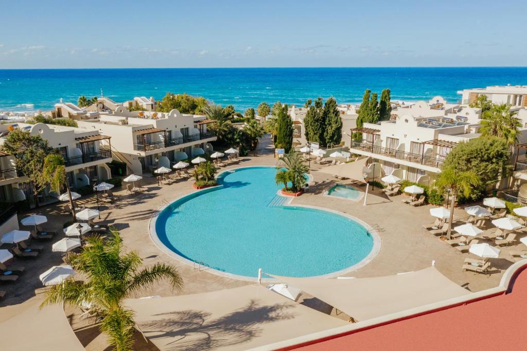 an aerial view of a resort with a swimming pool and the ocean at Louis Paphos Breeze in Paphos