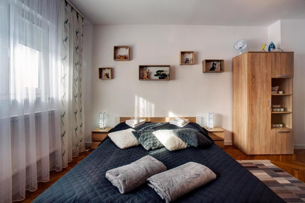 a bedroom with a bed with pillows on it at Apartamenty Bieszczady in Lesko
