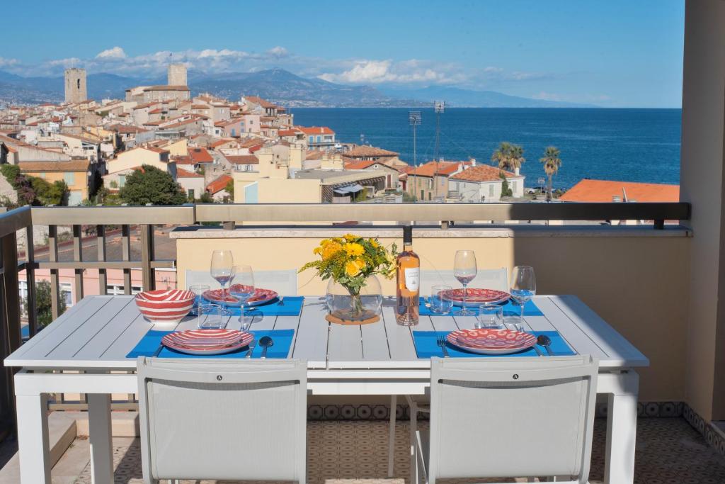 a table on a balcony with a view of a city at High Standing with Incredible Old Antibes and Sea views in Antibes