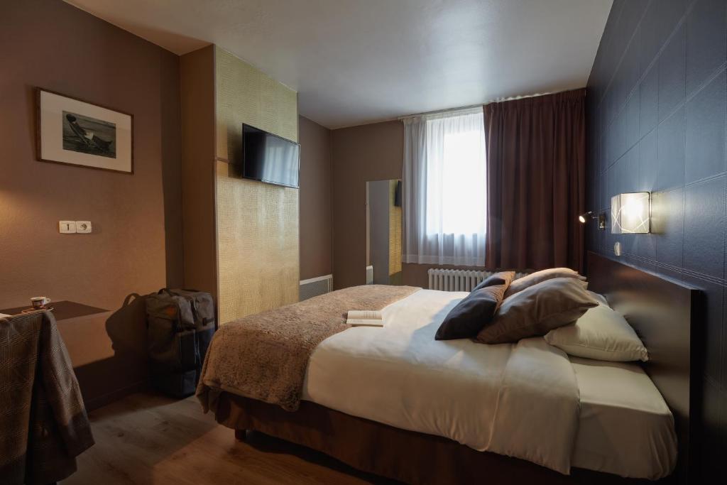 a hotel room with a bed and a window at Ashley Hôtel Le Mans Centre Gare in Le Mans