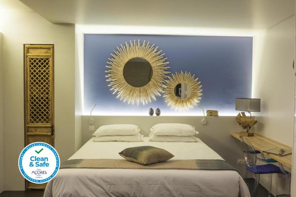 ラゴアにあるGraviana - Pedra Azul Charming Houseのベッドルーム1室(壁に鏡2つ付きのベッド1台付)