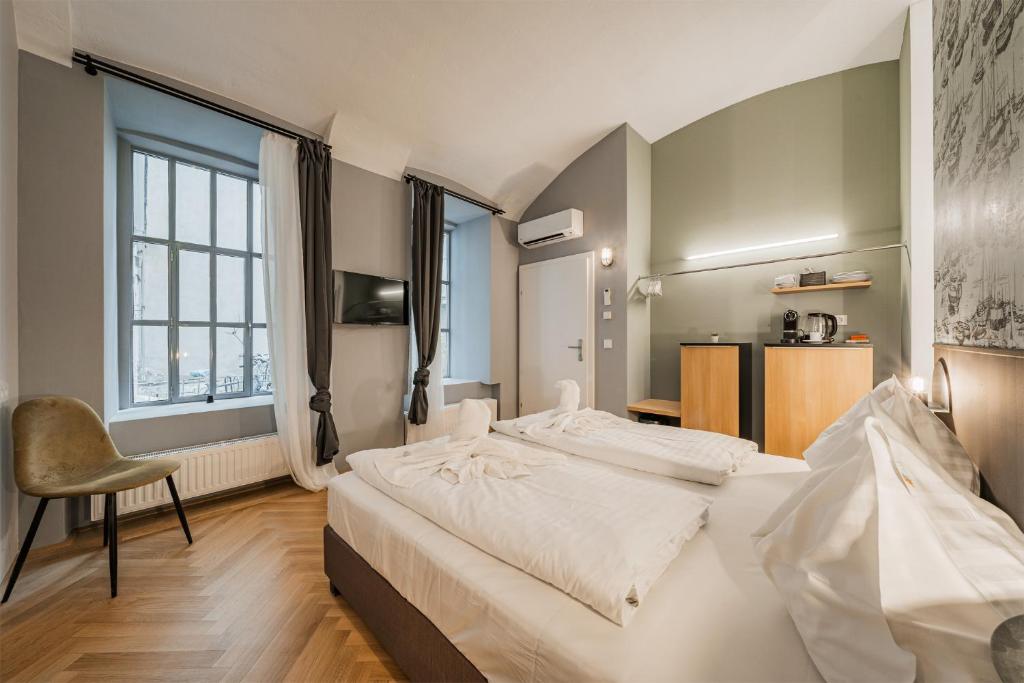 ein Schlafzimmer mit 2 Betten und einem Stuhl darin in der Unterkunft easy flat City Living in Wien