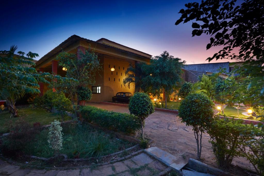 a house with a courtyard at night at WelcomHeritage Jungle Home Pench in Khawāsa