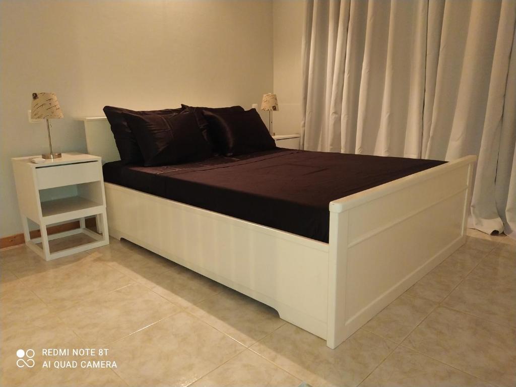 a white bed with black pillows on it in a bedroom at Apartamento Ferradura in Espargos