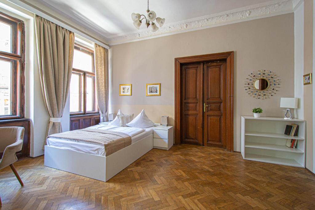 - une chambre avec un lit blanc et du parquet dans l'établissement For celebrations spacious 3BDR apartment with balcony, à Prague