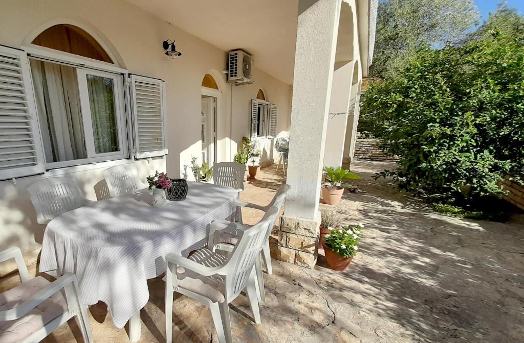 a white table and chairs on a patio at Apartment Barbarosa in Sveti Filip i Jakov