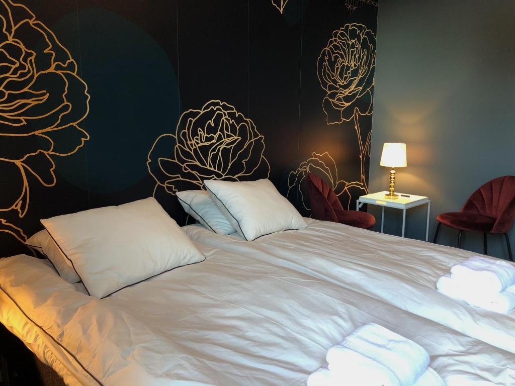 een bed met witte lakens en kussens in een kamer bij Mini-Hotel Borås Regementet in Borås