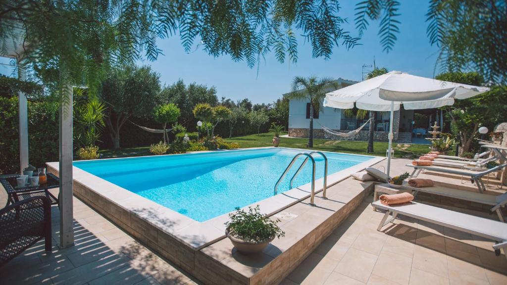 - une piscine avec une balançoire et un parasol dans l'établissement VILLA FERRADINA 4&2, Emma Villas, à Ispica