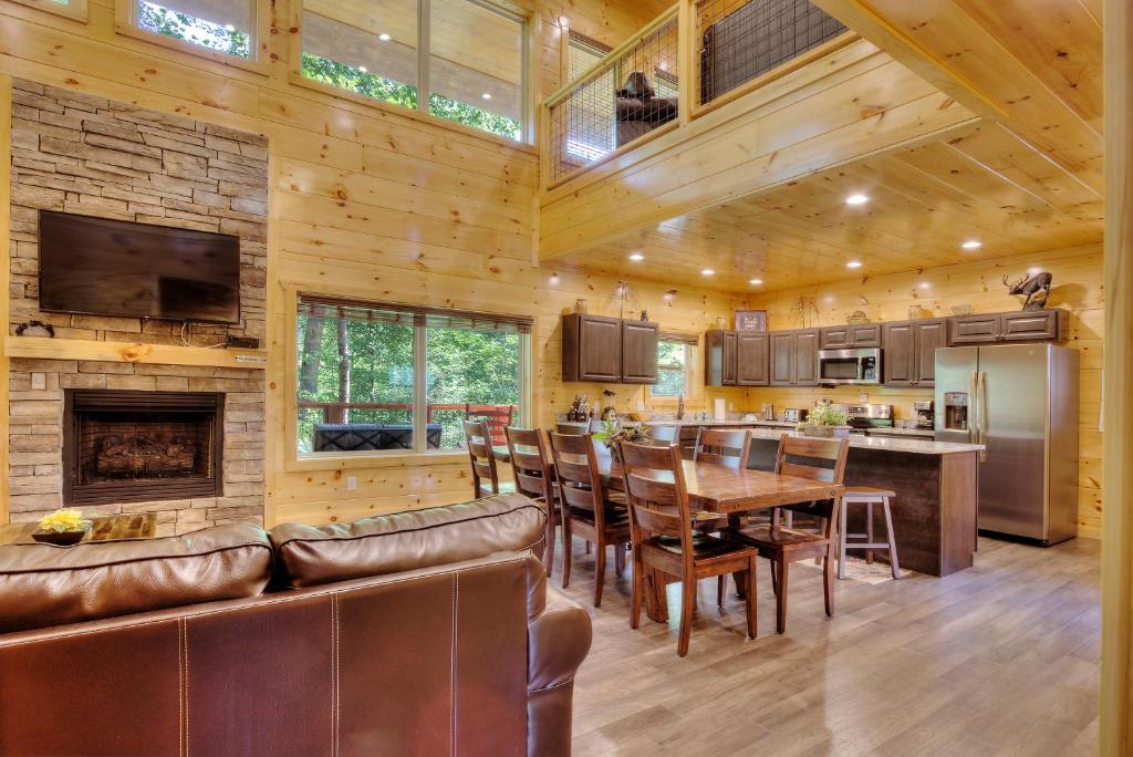 a kitchen and dining room with a table and a fireplace at Luxury 5bed/6ba Cabin: Theater, Pool Room, Hottub! in Gatlinburg