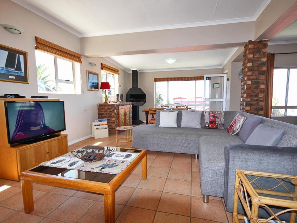 a living room with a couch and a tv at Schelde Apartment in Jeffreys Bay