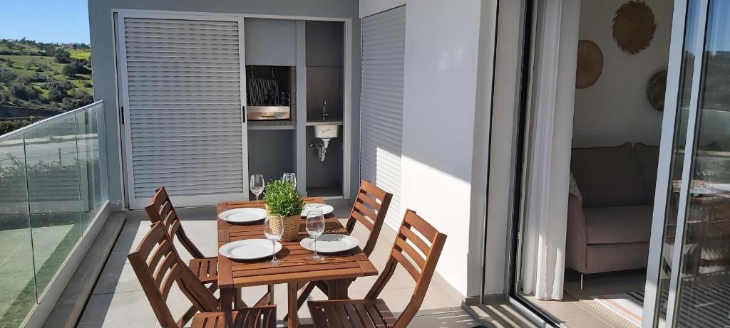 Albufeira beach apartment في ألبوفيرا: طاولة وكراسي خشبية على شرفة