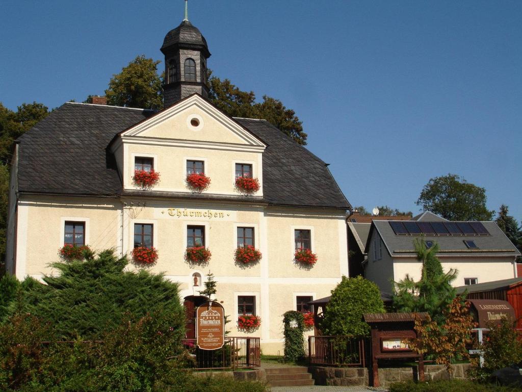 een wit gebouw met een klokkentoren erop bij Landhotel Thürmchen in Schirgiswalde