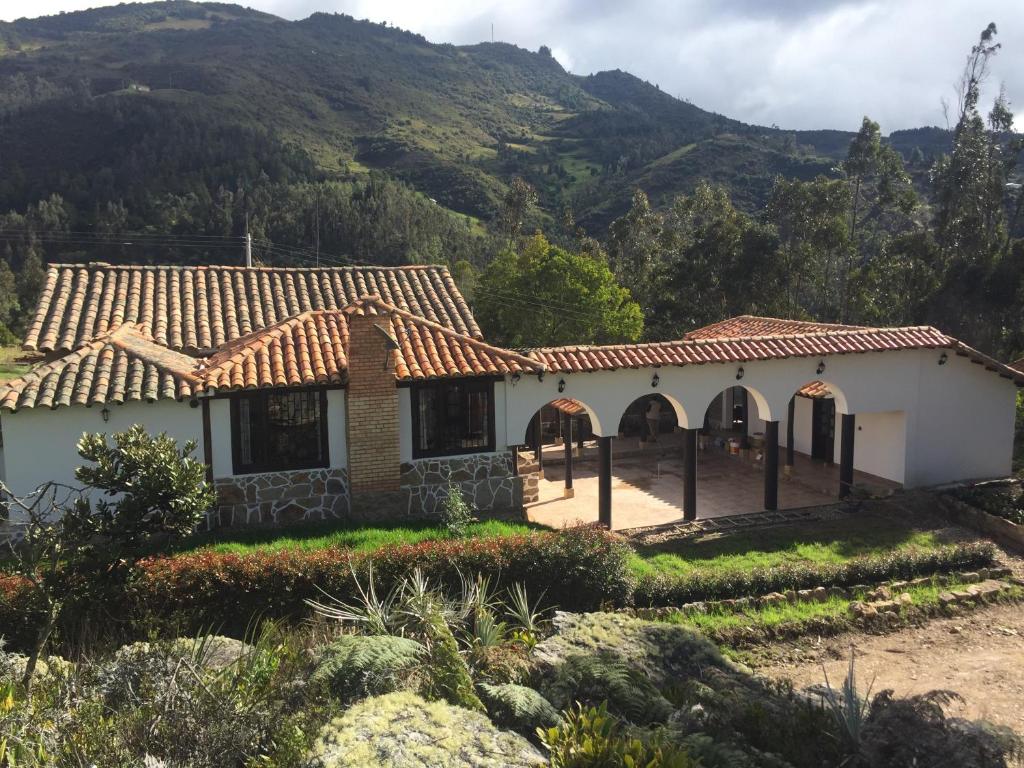 a house with a mountain in the background at La Casona Cucaita. Sede Campestre in Cucaita