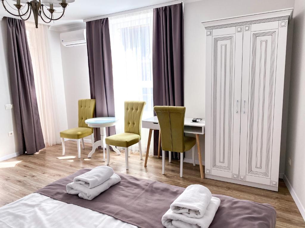 una camera con letto, tavolo e sedie di Opera Center Hotel & Apartments a Lviv