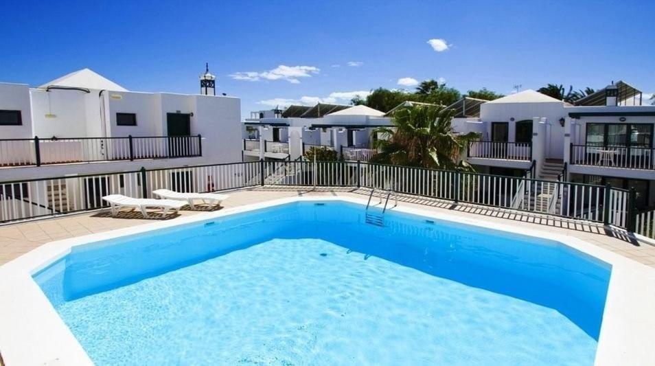 a swimming pool in the backyard of a house at Casa Josephine Lanzarote Spectacular sea views FREE WiFi in Puerto del Carmen