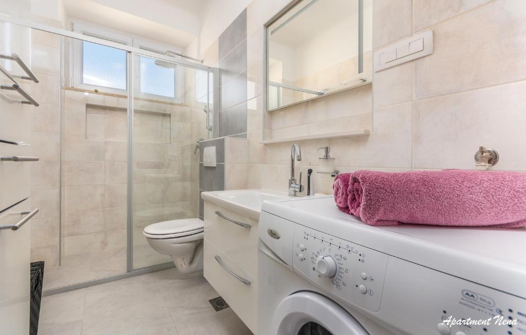 biała łazienka z umywalką i toaletą w obiekcie Apartmani Nena i Ilka w Puli