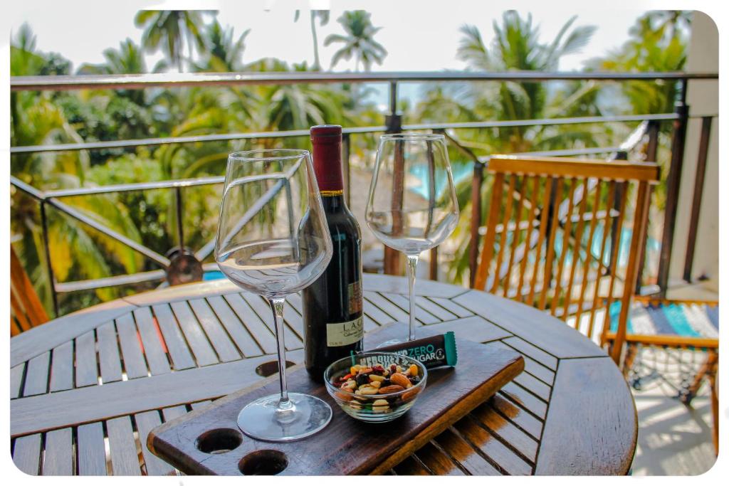 two wine glasses and a bowl of fruit on a table at "El Pajaro Carpintero" in Ixtapa