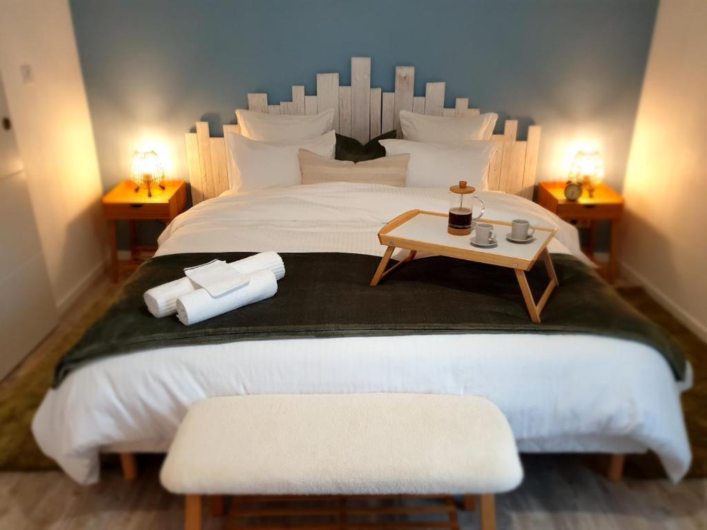 1 dormitorio con 1 cama blanca grande y mesa en Le Guèlèf - Appartement 2 personnes, en Orbey
