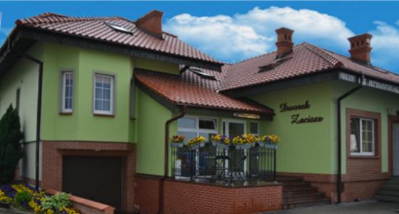 ein kleines grünes Haus mit Blumen auf dem Balkon in der Unterkunft Dworek Zacisze in Września