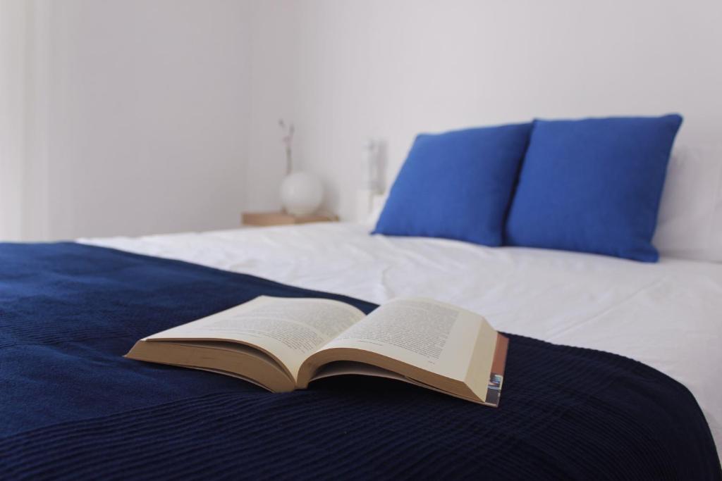 an open book sitting on top of a bed at Casas d'Almofala in Vila de Rei