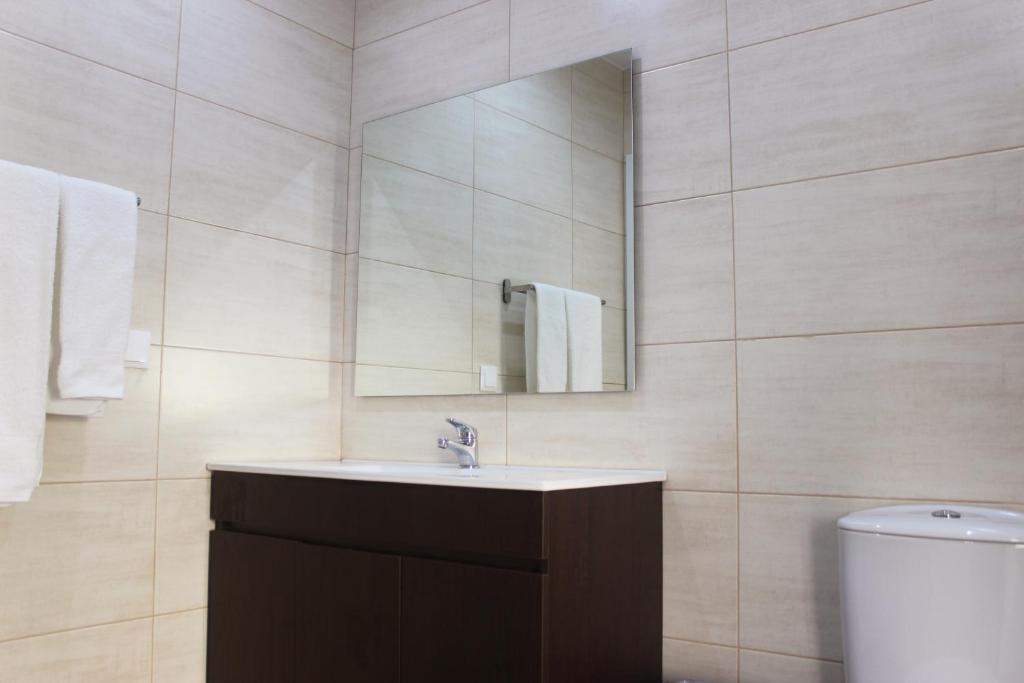 uma casa de banho com um lavatrio, um espelho e um WC. em Casas d'Almofala em Vila de Rei